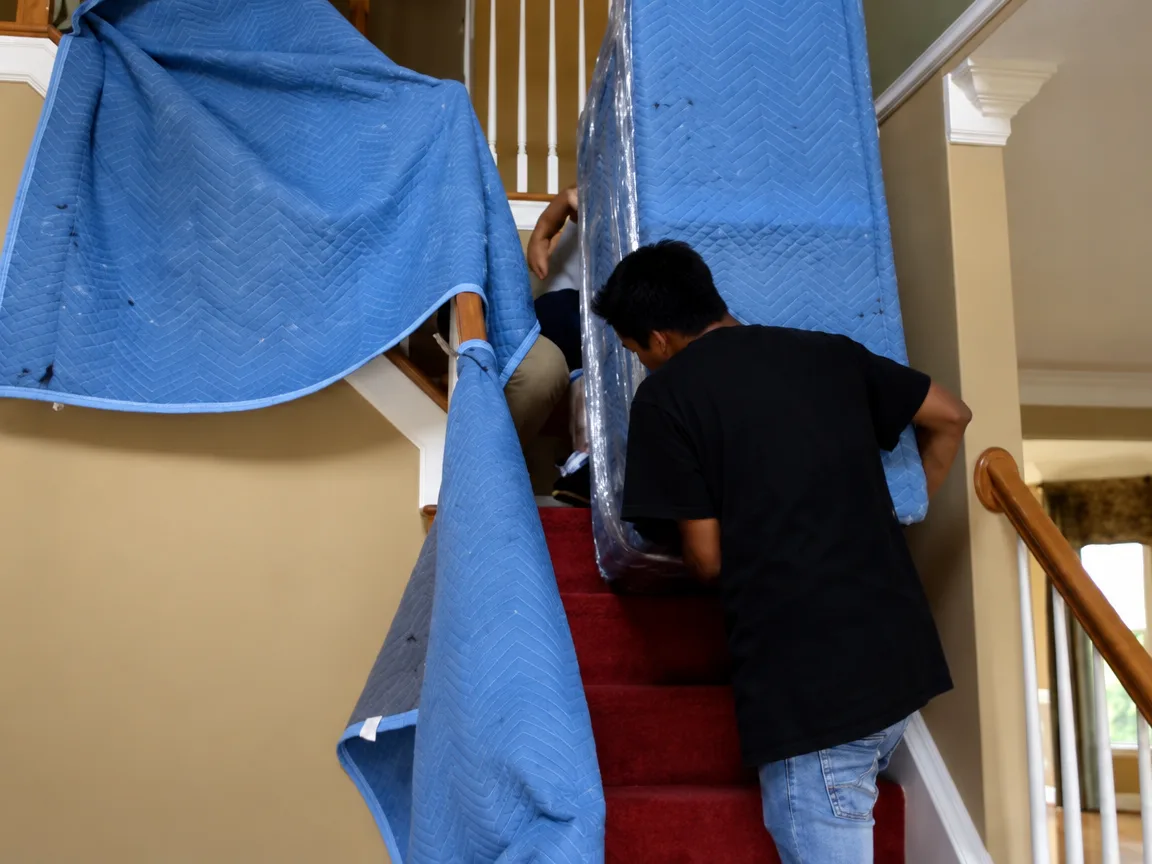 Movers preparing household items for transport