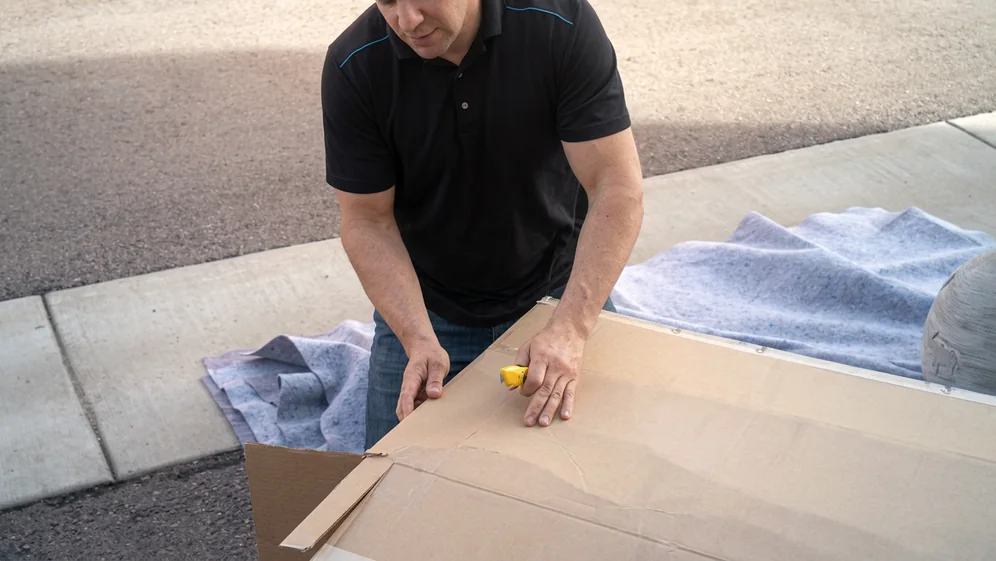 Movers preparing household items for transport